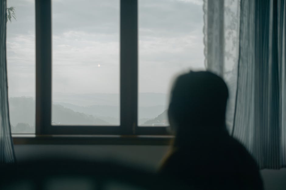 a person looking thoughtfully out a window at a natural landscape - retreat for depression and anxiety a person looking thoughtfully out a window at a natural landscape - retreat for depression and anxiety