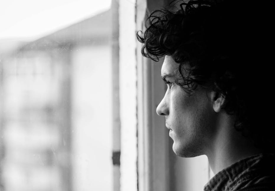 person looking thoughtfully out a window - retreats to treat depression person looking thoughtfully out a window - retreats to treat depression